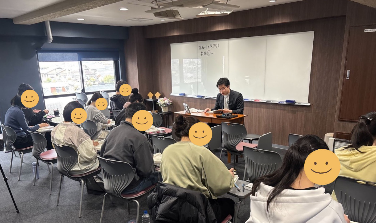 先生がホワイトボードを使って数学の勉強会で解説している様子